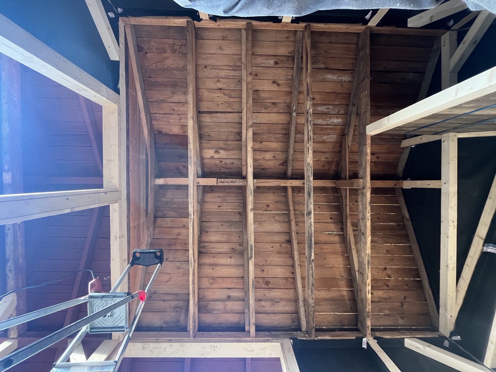 Gartenhaus-Dachkonstruktion von innen: Holzbalken und eingelassene Luke