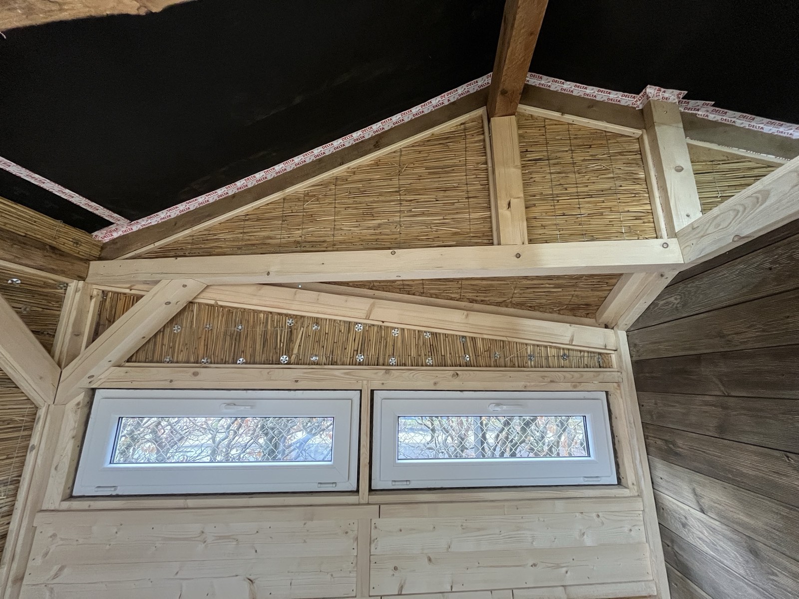 Gartenhaus-Innenraum fertig: Holzdielenboden, Lehmputzwände, Schilfrohrdecke